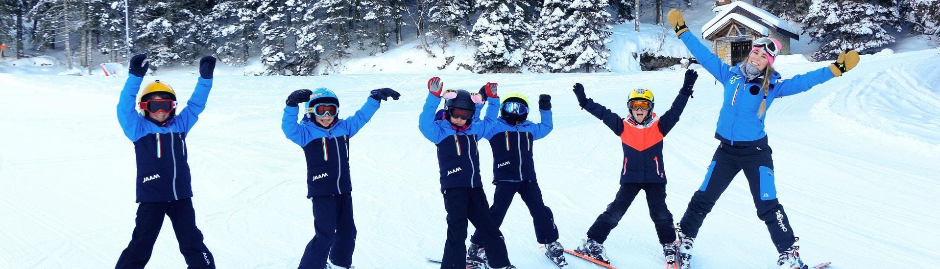 Un gruppo di bambini si diverte durante una delle loro lezioni di sci con un maestro di sci della Scuola di Sci e Snowboard Alpe Cimbra nel comprensorio sciistico di Folgaria.