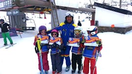 Un instructor y sus alumnos durante una clase de esquí para niños principiantes con Escuela Española de Esquí y Snow Sierra Nevada.