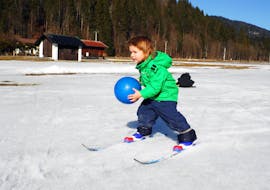 A young boy is learning to ski playfully during Private Cross Country Skiing Lessons for Families with the ski school Schneesportschule Morgenstern.