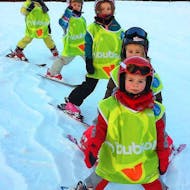 Des enfants skient à la queue-leu-leu pendant leur Cours de ski pour Enfants (3-6 ans) - Vacances avec l'école de ski ESI Font Romeu.