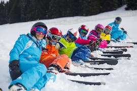 Young skiers are sitting in the snow between their ski instructors from the ski school ESI Font Romeu during their Kids Ski Lessons "Max 6" (6-12 years) - Holiday - All Levels.