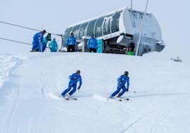 Deux skieurs s'élancent sur une piste enneigée du haut des remontées mécaniques pendant leur Cours de ski pour Adultes - Vacances - Tous niveaux avec l'école de ski Font Romeu.