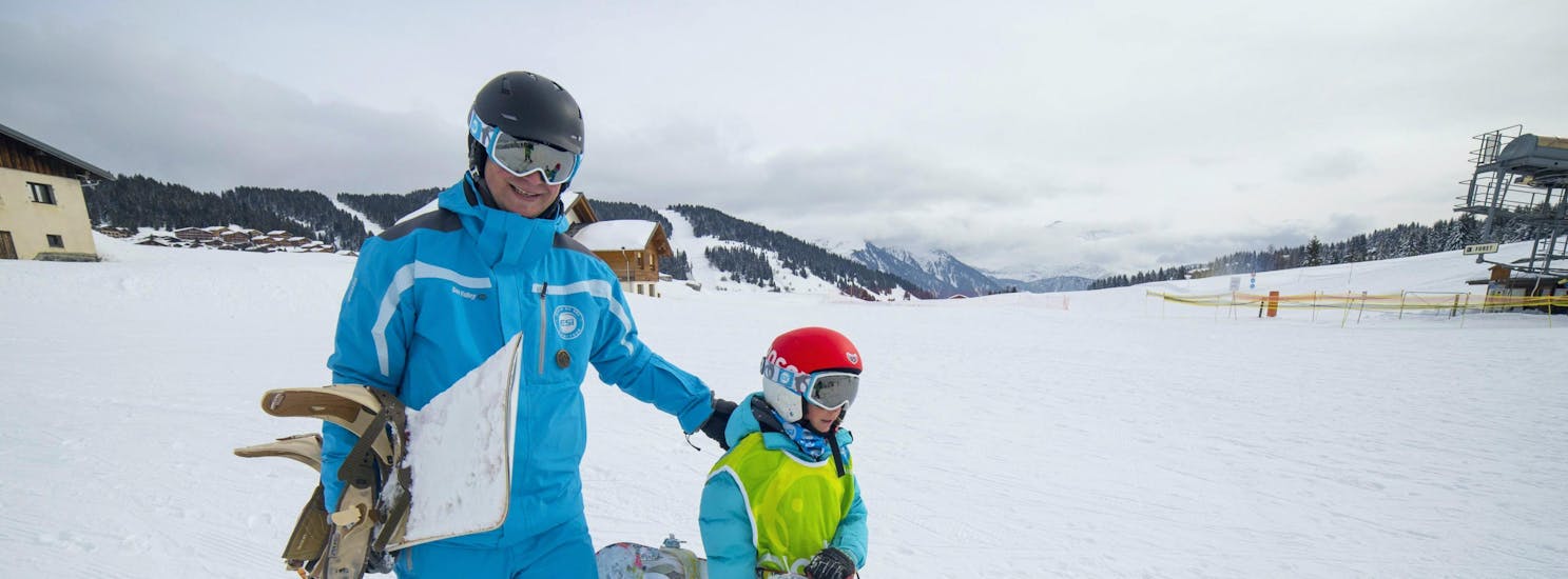 Un snowboardeur et son moniteur de snowboard de l'école de ski ESI Font Romeu marchent en bas des pistes enneigées pendant leur Cours de snowboard pour Enfants & Adultes - Vacances.