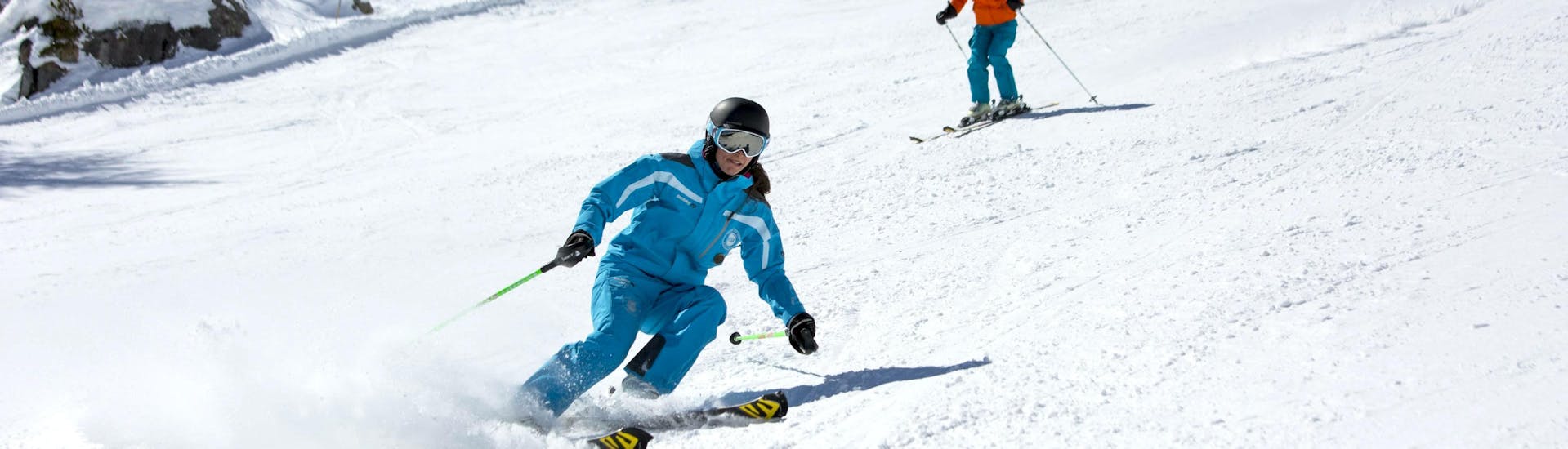 A skier is skiing down a snowy slope behind their ski instructor from the ski school ESI Font Romeu during their Private Ski Lessons for Adults - Holiday - All Levels.