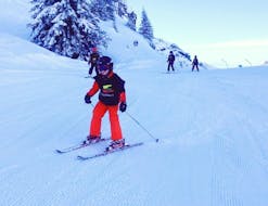 Un enfant skie le long d'une piste enneigée pendant son Cours particulier de ski pour Enfants - Tous niveaux avec l'école de ski Evolution 2 Morzine.