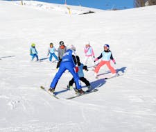 A group of kids enjoying their group ski lesson for advanced with Scuola di Sci Azzurra Livigno.