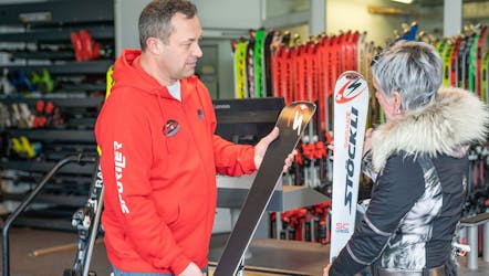 Le propriétaire donne des skis dans le magasin de  Location de ski Giggeralm Rentaski Brunico - Plan de Corones.