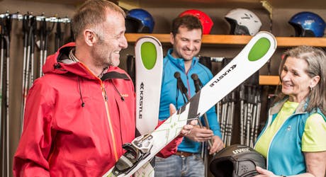Mitarbeiter hilft einer Kundin die richtigen Ski zu finden bei Skiverleih Sport Stöckl Gaschurn-Partenen.