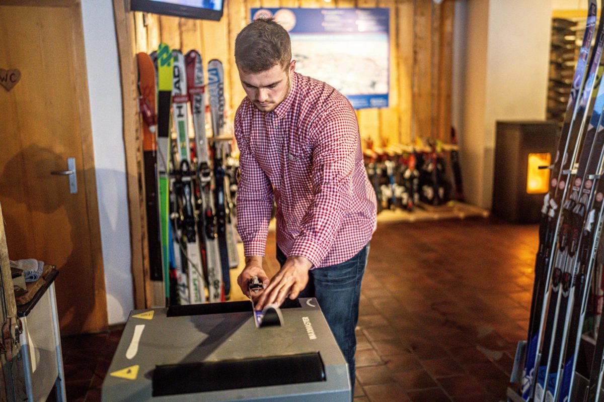 Employee of the Ski Rental Bergshop24 - Centre Predigtstuhl St. Englmar servicing the ski equipment.