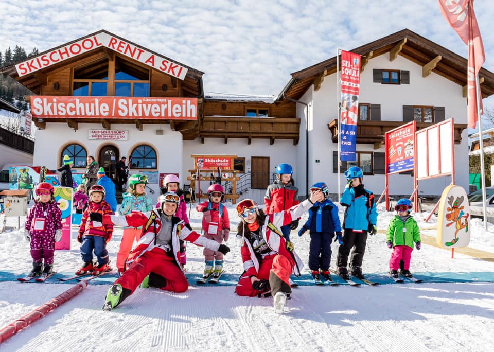 Team members with their students in front of Ski Rental & School Ellmau Hartkaiser.