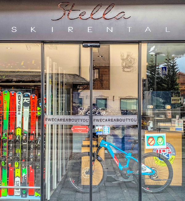 Front window of Top Ski Rental Selva Val Gardena with skis and snowboards on display.